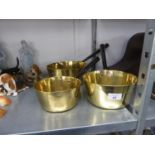 A GRADUATED SET OF THREE BRASS, STEEL HANDLED SAUCEPANS (3)