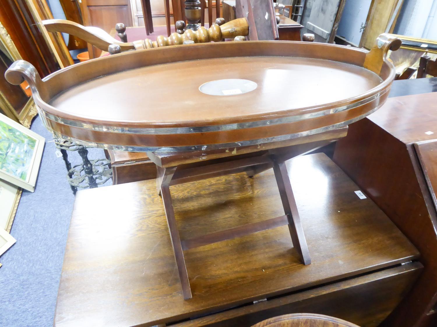 MODERN WHITE METAL BANDED MAHOGANY TWO HANDLED OVAL BUTLER'S TRAY ON STAND, the galleried tray