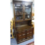 PROBABLY PRIORY, DARK OAK STAINED SIDE CABINET, the upper section with carved cornice and pair of