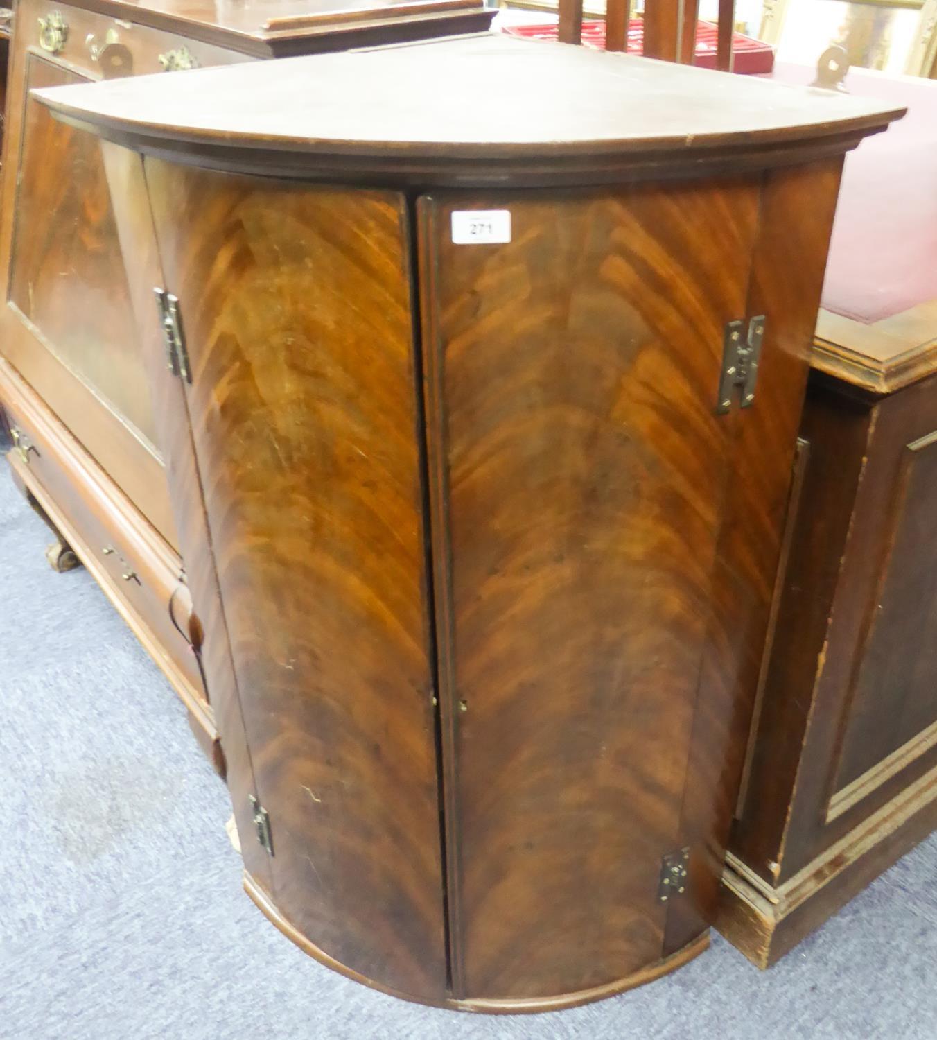 GEORGIAN FLAME CUT MAHOGANY BOW FRONTED CORNER CUPBOARD, of typical form with exposed brass H hinges