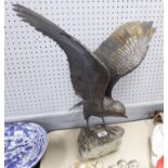 HELEN DARE, METAL SCULPTURE OF A BIRD OF PREY ALIGHTING ON A ROCK, signed on a tablet on the stone