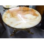 AN ORNATE BRASS CIRCULAR COFFEE TABLE WITH ONYX TOP