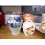 AN ORANGE GLAZED POOLE POTTERY VASE, A SMALLER FLORAL VASE, ANOTHER VASE AND A FLORAL DECORATED