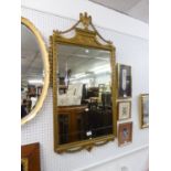 A REGENCY STYLE GILT FRAMED WALL MIRROR, WITH URN AND FESTOON PEDIMENT