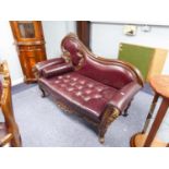 AN ORNATE SMALL SETTEE/ CHAISE, WITH DOUBLE SCROLL ARMS, COVERED IN DARK RED LEATHER (with fire