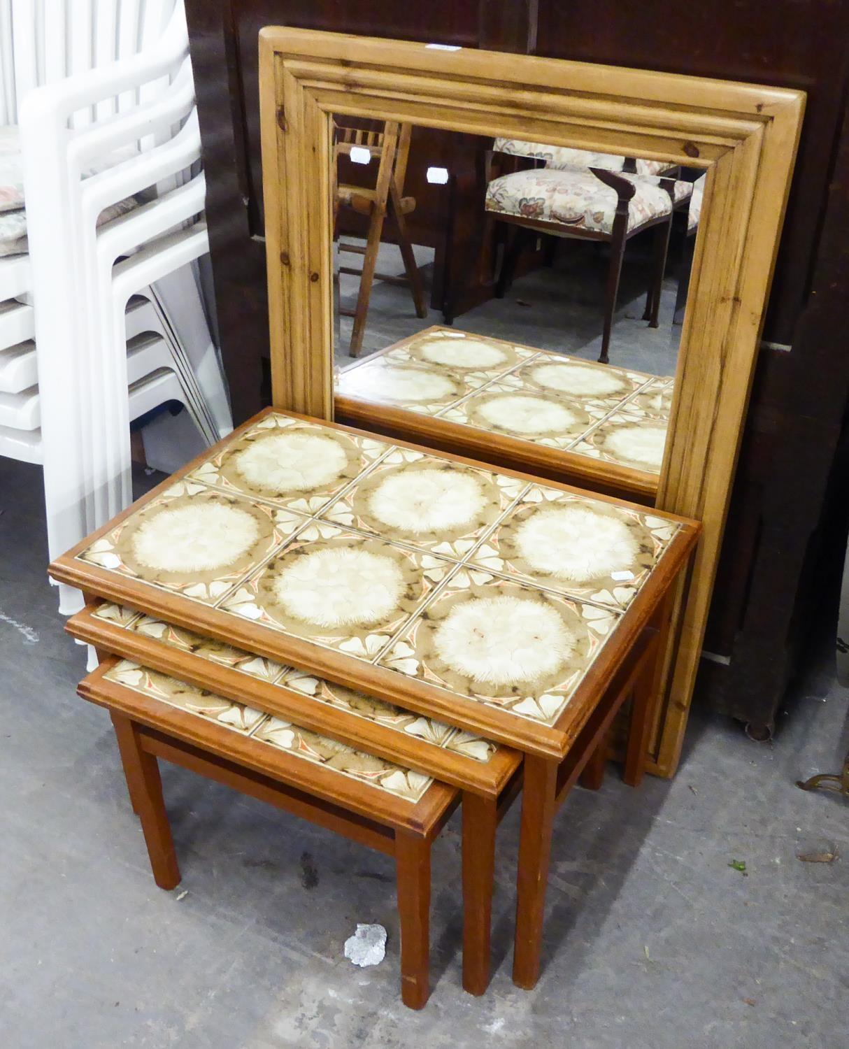 A PINE FRAMED WALL MIRROR AND A NEST OF 3 COFFEE TABLES WITH TILED TOP