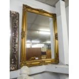 A LARGE GILT FRAMED BEVELLED EDGE WALL MIRROR