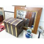 AN OAK FRAMED WALL MIRROR WITH GILT DECORATION, AND A LOG BOX IN THE FORM OF A TRUNK (2)