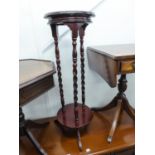 A MAHOGANY TWO TIER CIRCULAR JARDINIERE STAND WITH THREE SPIRALLY TWISTED COLUMNS AND TRIPOD FEET