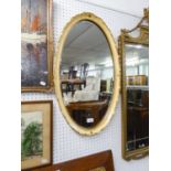 AN OVAL BEVELLED EDGE WALL MIRROR, IN CREAM AND GILT CAVETTO FRAME