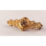 VICTORIAN 9ct GOLD WING SHAPED BROOCH with embossed decoration, the centre set with tiny ruby and