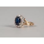 SAPPHIRE AND DIAMOND CLUSTER RING, an oval sapphire within a border of round brilliant cut diamonds,
