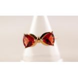 9ct GOLD RING SET WITH A PAIR OF OPPOSED TRIANGULAR SHAPED RED ANDESINE, in a bow shaped setting,