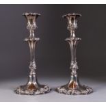 PAIR OF EARLY VICTORIAN SILVER TABLE CANDLESTICKS embossed with rococo foliate scrolls each having a