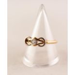 18ct TWO COLOUR GOLD RING, the knot pattern top collet set with a round brilliant cut diamond,