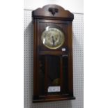 AN EARLY/MID TWENTIETH CENTURY OAK CASED WALL CLOCK, HAVING SILVERED DIAL AND BLACK NUMERALS OVER