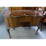 A MAHOGANY KIDNEY SHAPED DESK WITH LEATHER INSET TOP, FIVE DRAWERS, ON FOUR CARVED CABRIOLE SUPPORTS