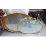 AN OVAL OAK FRAMED WALL MIRROR AND A GILT OVAL WALL MIRROR WITH FANCY PEDIMENT (2)