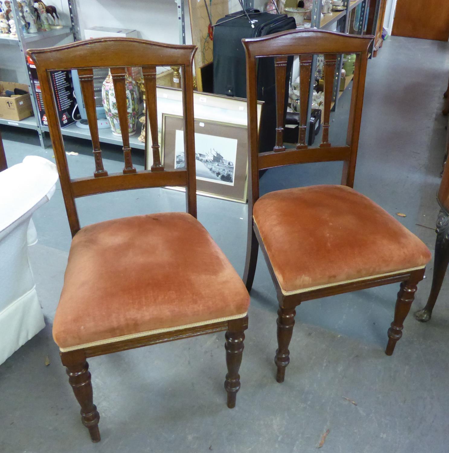 A SET OF FOUR VICTORIAN MAHOGANY DINING CHAIRS, HAVING THREE SHAPED BACK SPLATS OVER PAD SEATS, ON