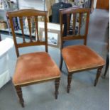 A SET OF FOUR VICTORIAN MAHOGANY DINING CHAIRS, HAVING THREE SHAPED BACK SPLATS OVER PAD SEATS, ON