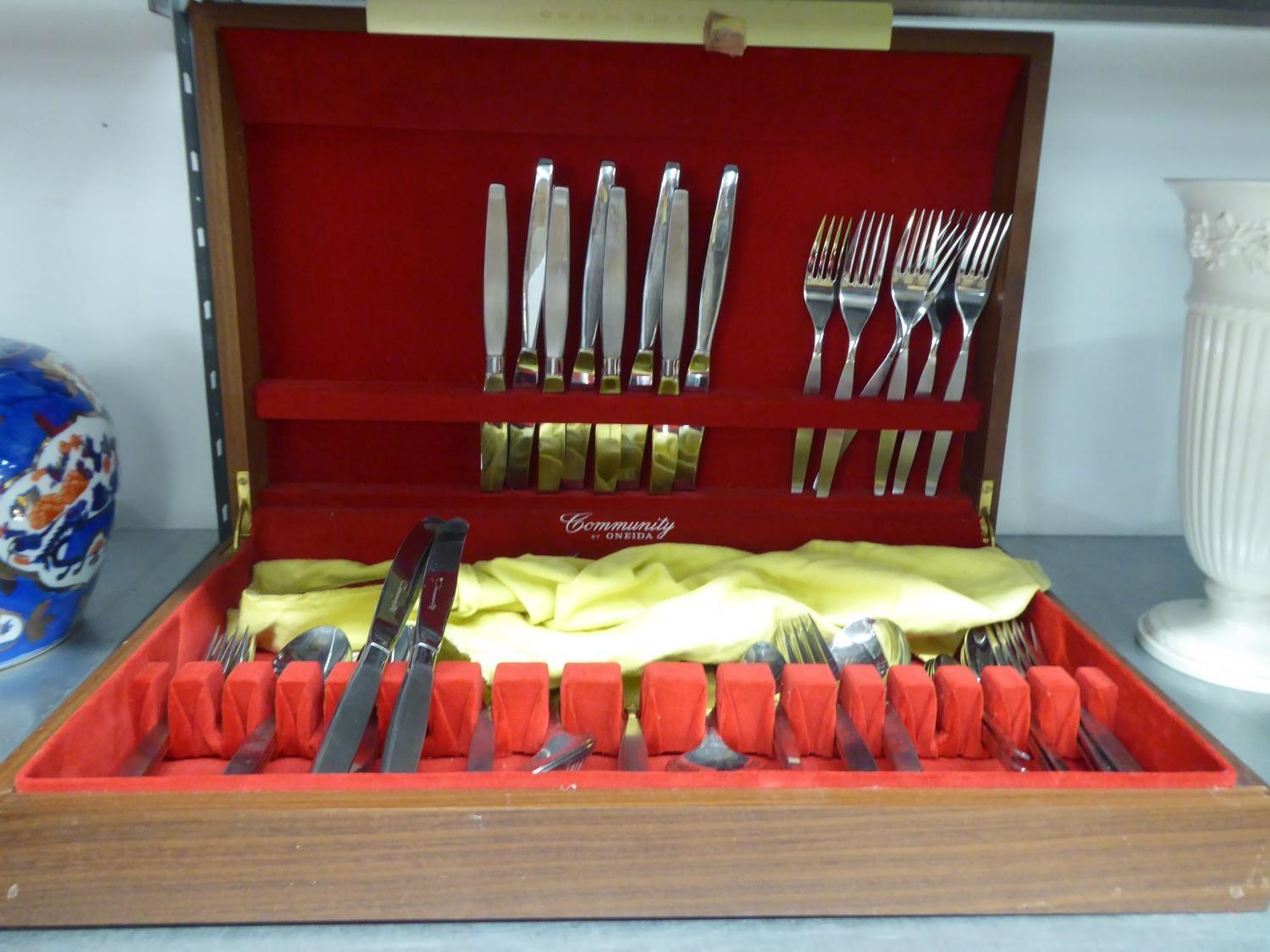 A TEAK TABLE TOP CANTEEN, CONTAINING A TABLE SERVICE OF 'COMMUNITY' STAINLESS STEEL CUTLERY BY '