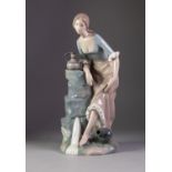 NAO PORCELAIN LARGE FIGURE OF A YOUNG GIRL WASHING HER FEET AT A WELL, 13 ½? (34.3cm) high,