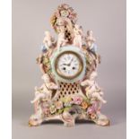 GERMAN PORCELAIN CASED MANTEL CLOCK OF NEO ROCOCO SCROLLIATE FORM animated with six putti and floral