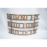 CURVED WROUGHT IRON ADVERTISING SIGN ?BURNLEY BUILDING SOCIETY?, with gilt lettering on three bands,