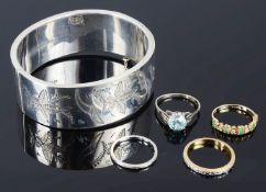 A large silver hinged scroll bangle and a collection of rings