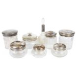 A collection of Victorian and later silver topped dressing table jars