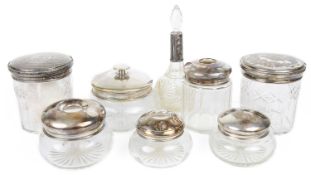 A collection of Victorian and later silver topped dressing table jars