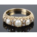 An attractive Victorian style pearl and diamond set scroll mounted ring