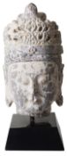 A large Chinese carved stone head of the Buddha in archaic style