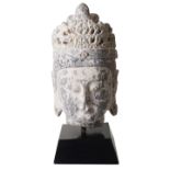 A large Chinese carved stone head of the Buddha in archaic style