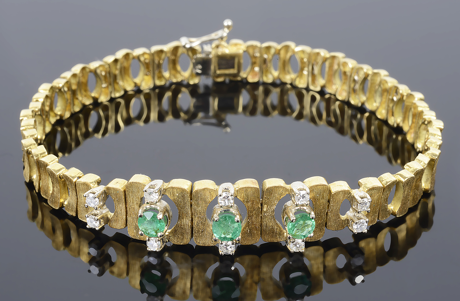 An attractive Continental emerald and diamond set articulated bracelet