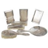 Three silver photograph frames, a four piece silver brush and mirror set