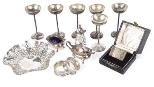 A collection of assorted silver, napkin rings, bon bon dish, cruets, silver cups