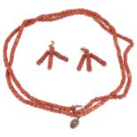 A deep red coral bead two row necklace and drop earrings