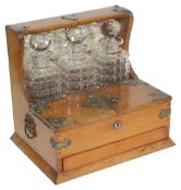 An Edwardian oak cased three bottle Tantalus