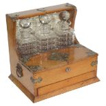 An Edwardian oak cased three bottle Tantalus