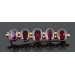 An attractive Georgian foil backed flat cut garnet set bar brooch