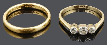 A three stone diamond set ring together with a 22ct gold wedding band