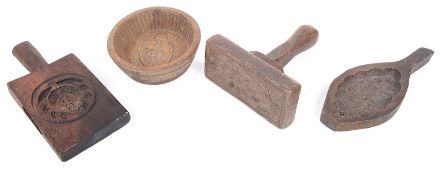 A collection of treen butter moulds and pats