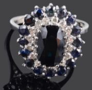 A Continental contemporary sapphire and diamond oval cluster ring