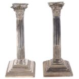 A near pair of Victorian Corinthian column candlesticks