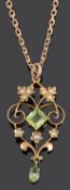 A delicate Edwardian peridot and seed pearl scroll pendant on chain