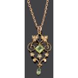 A delicate Edwardian peridot and seed pearl scroll pendant on chain