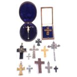 A large flat cut garnet set cross brooch and a collection of various other crosses