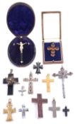 A large flat cut garnet set cross brooch and a collection of various other crosses