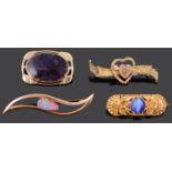 An Egyptian style 22ct gold brooch and three other gold brooches